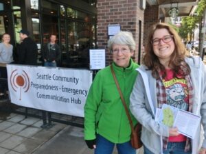 Two women are smiling and showing flyers