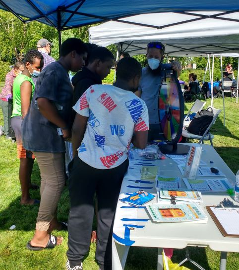 a crowd of boys are spinning a wheel to answer disaster questions